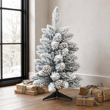 Compact snow-flocked pinecone Christmas tree beside a winter window