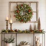 Pre-lit berry and pinecone Christmas wreath displayed on a rustic window frame