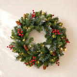 Close view of the lit green wreath with red berries and pinecones