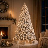 Pre-lit snow-flocked Christmas tree glowing beside a fireplace