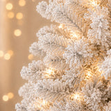 Close-up of heavily flocked PVC branch tips and warm lights