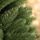Close-up of dense green PVC branch tips on the artificial Christmas tree
