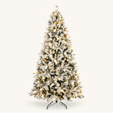 Snow-flocked pre-lit artificial Christmas tree with warm glowing globe lights