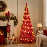 Red pre-lit pop-up Christmas tree beside a decorated holiday fireplace